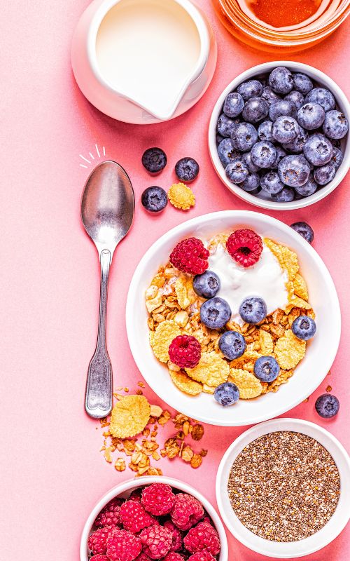 Verschiedene Bowls mit Müsli, Obst und Kornflackes