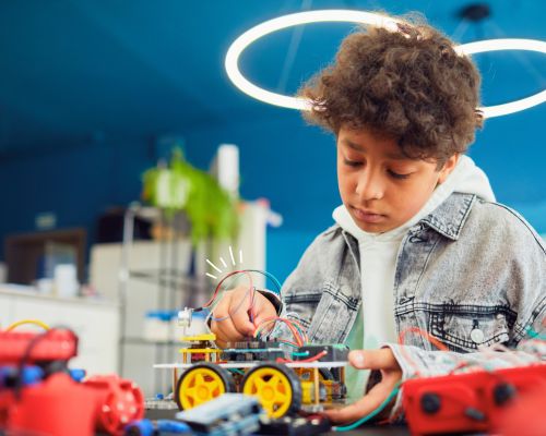 erfinder-werkstatt-foto-2 Kind im weißen Kittel hält Reagenzgläser