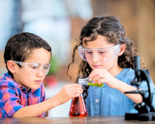 onlinekurs-chemie-labor-kids-foto-2 Kind im weißen Kittel hält Reagenzgläser